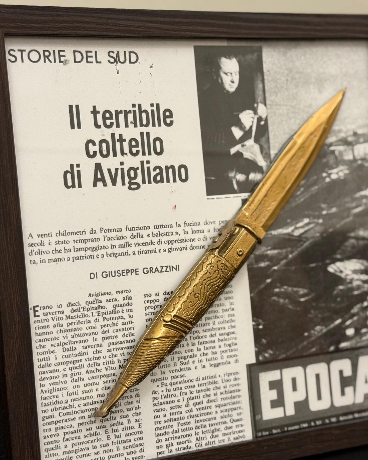 Balestra — coltello in rilievo dorato su collage di pagine di giornale d'epoca, cornice nera