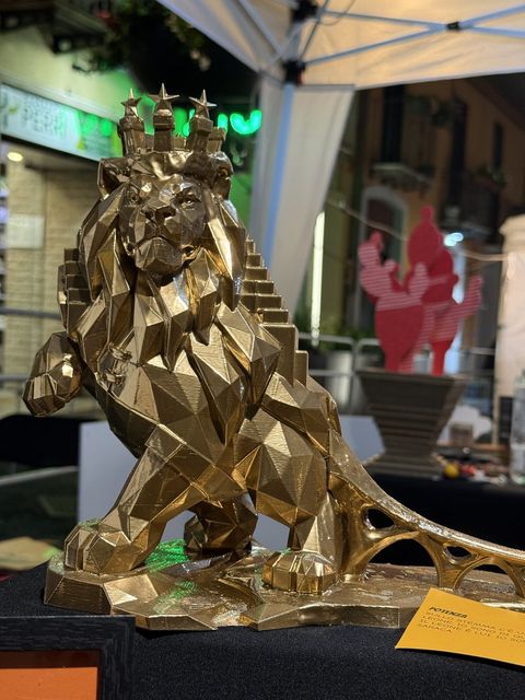 Il Leone di Potenza, scultura dorata a facce con corona di torri, scale e ponte