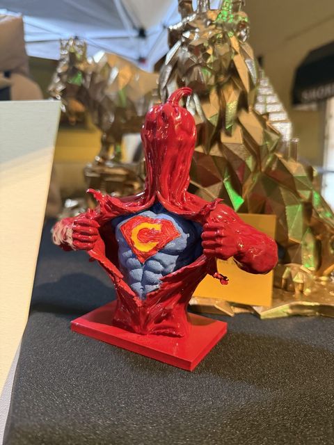 Super Crusco, busto rosso del peperone crusco che si apre la camicia mostrando lo stemma da supereroe